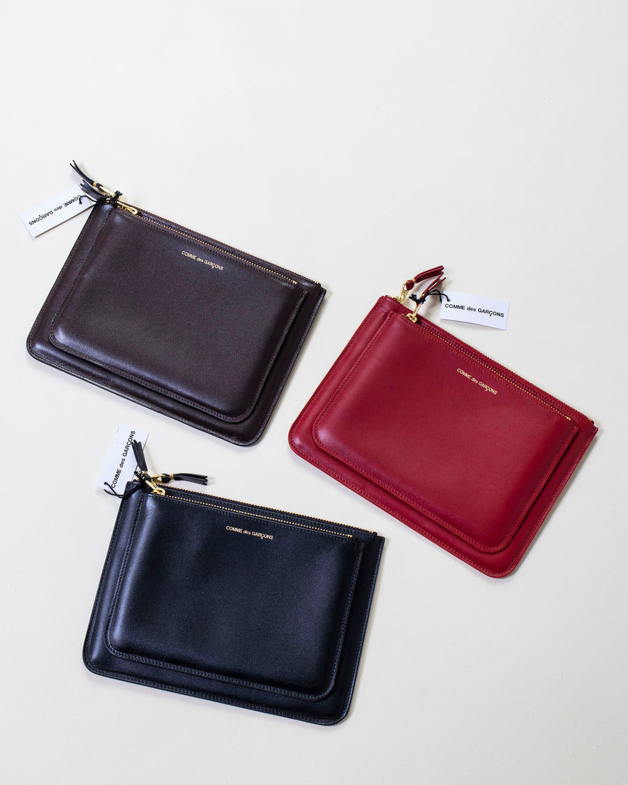 comme des garçons outside pocket zip top pouch • colors: brown, red & black • smooth leather • zip top closure at pouch and outside pocket • gold toned hardware  • 8 1/2